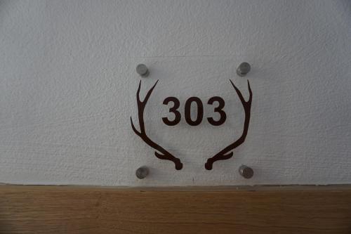 a sign with deer antlers on a wall at Appartementhaus Hüttenberger in Erpfendorf