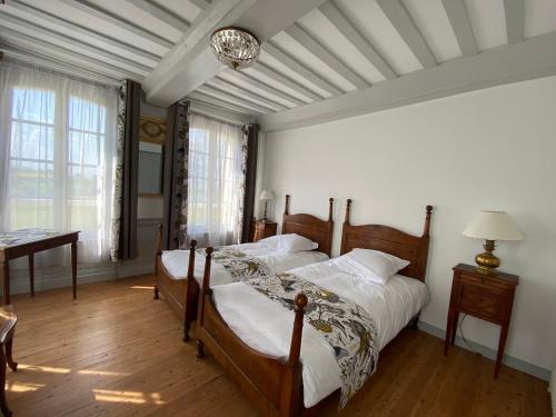 a bedroom with two beds and a table and a window at Manoir de L'Oiselière in La Remuée