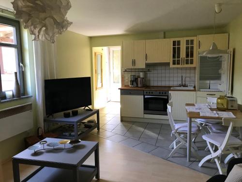 a kitchen and living room with a table and chairs at Ferienwohnung Laaslich in Laaslich