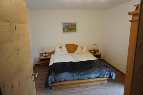 a bedroom with a bed with two night stands and two lamps at Appartementhaus Hüttenberger in Erpfendorf