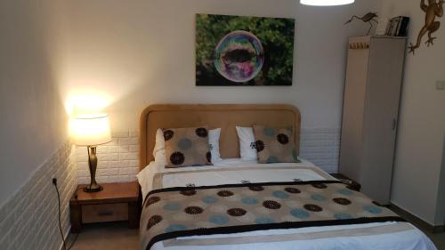 - une chambre avec un lit et une peinture murale dans l'établissement Beatrice Hospitality, à Neve Zohar