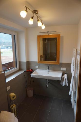 a bathroom with a sink and a window at Appartementhaus Hüttenberger in Erpfendorf