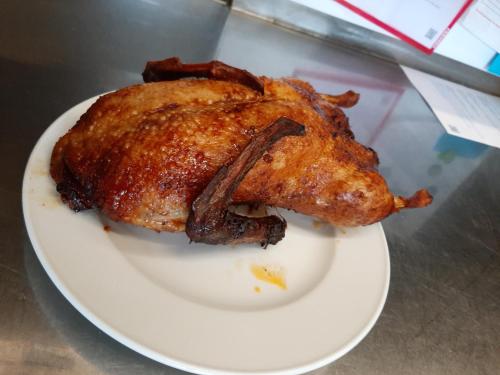 a chicken on a white plate on a table at Gasthof Liederhalle in Aalen