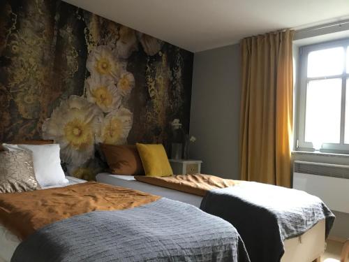 a bedroom with two beds and a floral wall at Ferienwohnung Laaslich in Laaslich