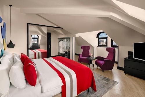 a bedroom with a red and white bed and purple chairs at Sura Hagia Sophia Hotel in Istanbul