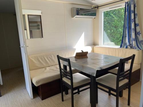 une salle à manger avec une table, des chaises et un canapé dans l'établissement Mobil-Home Saint Cheron, à Saint-Chéron