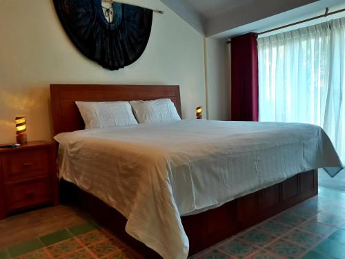 a bedroom with a large bed and a window at Pink Tulip Hoi An in Hoi An