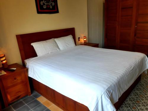 a bedroom with a large bed with white sheets at Pink Tulip Hoi An in Hoi An