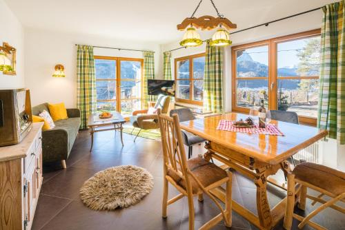 uma cozinha e sala de estar com mesa e cadeiras em Zur Schönen Aussicht Hotel garni em Garmisch-Partenkirchen