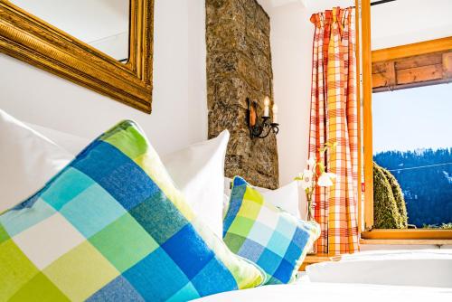 a bedroom with a bed with a mirror and pillows at Zur Schönen Aussicht Hotel garni in Garmisch-Partenkirchen