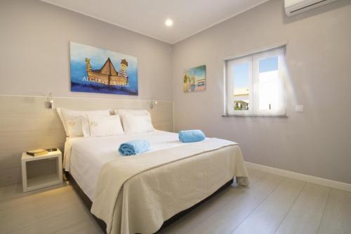 Un dormitorio con una gran cama blanca y una ventana en Villa Bellevue 4, en Albufeira