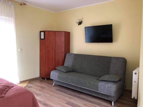 a living room with a couch and a flat screen tv at "Pokoje u Ireny"-pokój z aneksem in Sztutowo