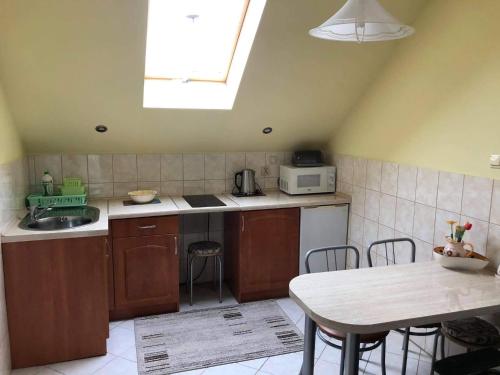 a kitchen with a sink and a table with chairs at "Pokoje u Ireny"-pokój z aneksem in Sztutowo