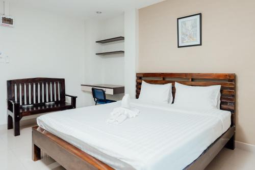 um quarto com uma cama grande e uma cadeira em Corner One Residence em Hat Yai