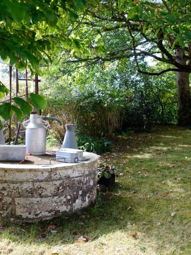 a stone fountain in a yard with a tree at LA PARENTHÈSE in Saubrigues