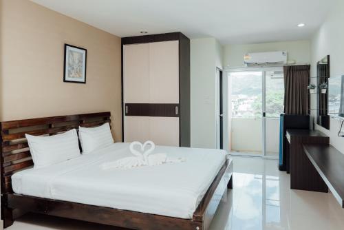 um quarto com uma cama branca com um laço em Corner One Residence em Hat Yai