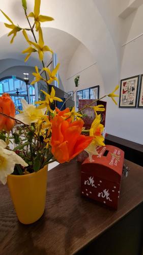 a yellow vase with flowers on a table at Hotel Cranach-Herberge City Centre in Lutherstadt Wittenberg