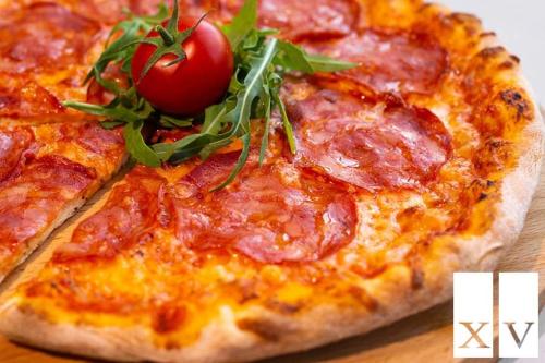 a pizza with a tomato on top of it at City Central Apartment in Yerevan