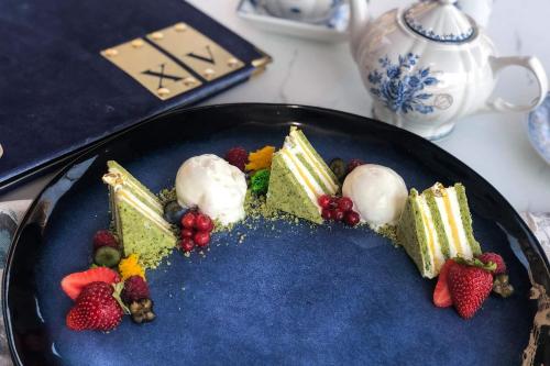 a blue plate with cake and fruit on it at City Central Apartment in Yerevan