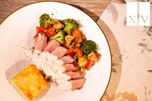 a plate of food with meat rice and broccoli at City Central Apartment in Yerevan