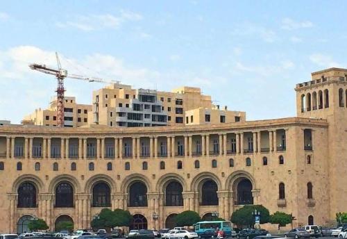 a large building with cars parked in front of it at City Central Apartment in Yerevan