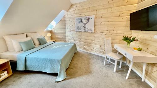 a bedroom with a bed and a desk and a television at Jaszowianka Best For You in Ustroń