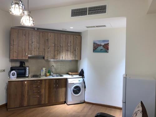 a kitchen with a sink and a washing machine at City Central Apartment in Yerevan