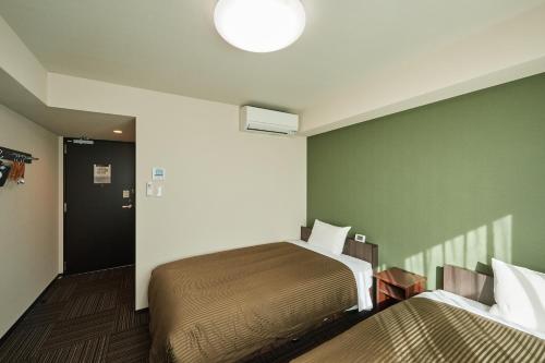 Ένα ή περισσότερα κρεβάτια σε δωμάτιο στο Hotel Trend Kyobashi Ekimae