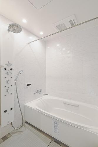 a white bathroom with a tub and a shower at Mon Petit Chat in Kanazawa