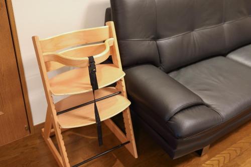 a wooden chair next to a leather couch at Mon Petit Chat in Kanazawa