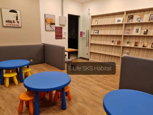 a waiting room with blue tables andools in a store at E Life SKS Habitat With WiFi Netflix in Johor Bahru