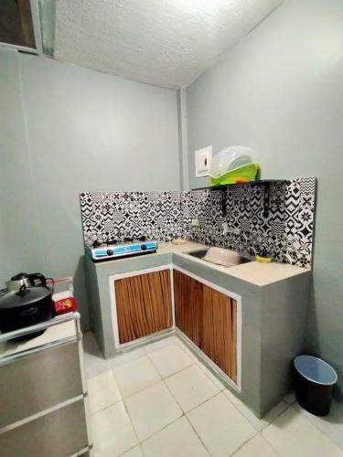 een keuken met een wastafel en een aanrecht bij DJCI Apartelle with own Kitchen & Bath 103-212 in Cabanatuan