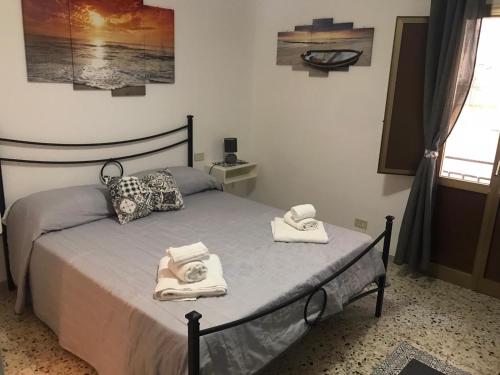 ein Schlafzimmer mit einem Bett mit Handtüchern darauf in der Unterkunft Affittacamere Le Isole in Trapani