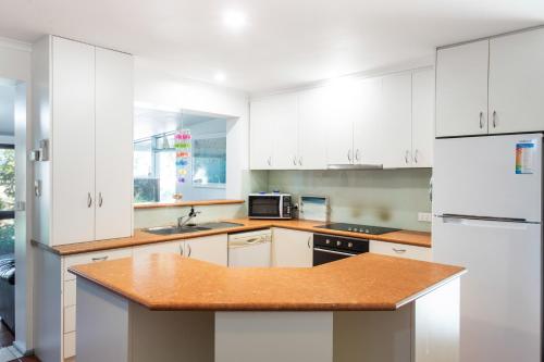 a kitchen with white cabinets and a wooden counter top at Relax in San Remo in San Remo