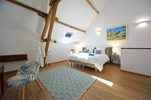 a bedroom with a bed and a chair in it at La Martinière in Saint-Aubin-Fosse-Louvain