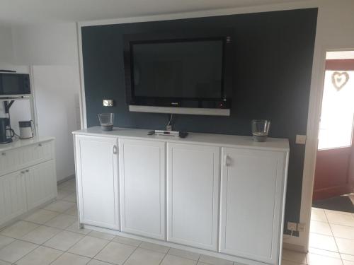 a white cabinet with a flat screen tv on a wall at FeWo24-Prasdorf in Prasdorf