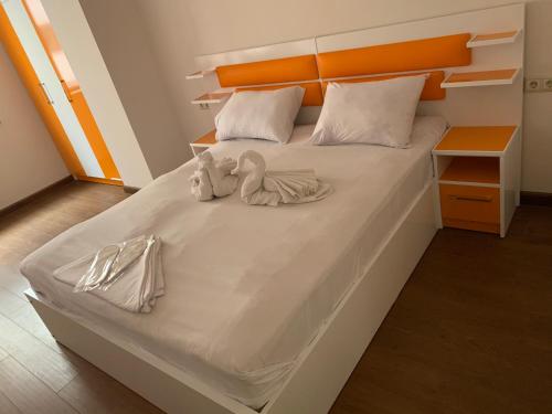 a white bed with two stuffed animals on it at City Central Apartment in Yerevan