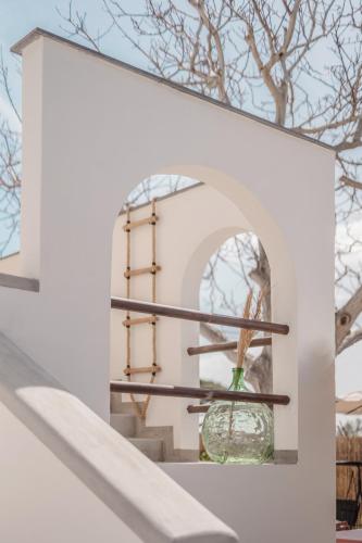 a window in a white building with a vase at Cala Cala Rooms,Restaurant & Farm Experience in Procida
