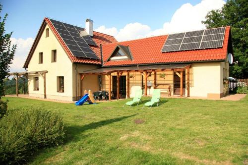 a house with solar panels on the roof at Taneček - malý apartmán u rodinného domu in Stvolínky