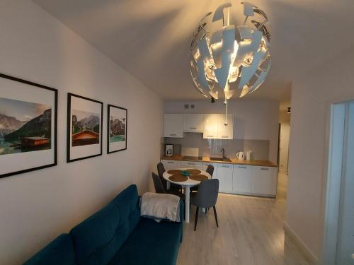 - un salon avec un canapé bleu et une table dans l'établissement Apartament Rose 9 Świnoujście, à Świnoujście