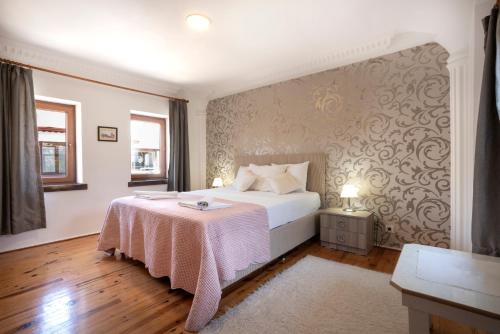 a bedroom with a white bed with a pink blanket at Beach House Apartment in Side