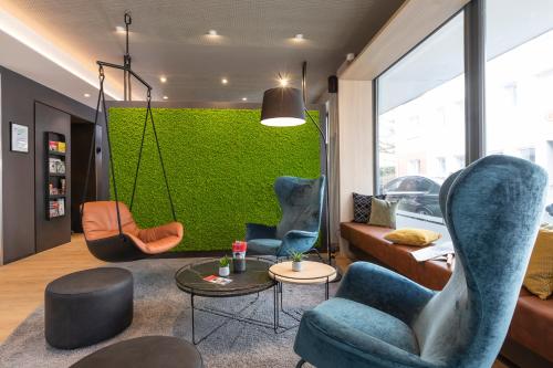 a living room with chairs and a green wall at zeitwohnhaus SUITE-HOTEL & SERVICED APARTMENTS in Erlangen