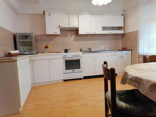 a kitchen with white cabinets and a sink and a microwave at Bela golobica Bogojina in Bogojina