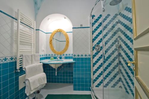 a blue tiled bathroom with a sink and a shower at Palazzo Rocco all 3 villas - Weddings in Praiano