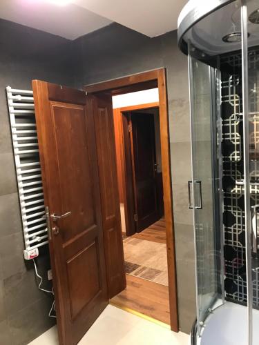 コパオニクにあるApartman B3 u vili Suriのバスルーム(シャワー付)、木製のドアが備わります。