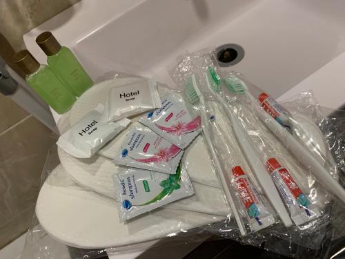 a pile of toothbrushes and toothpaste on a toilet at City Central Apartment in Yerevan