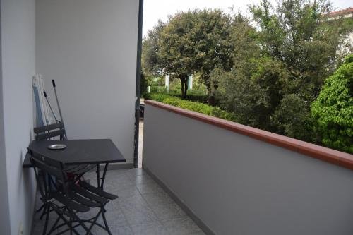 a balcony with a table and chairs looking out a window at Orchidea Marina in Tirrenia