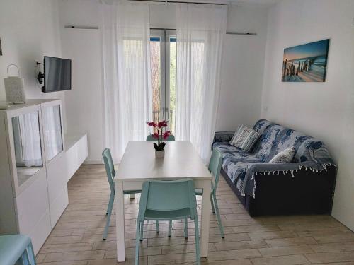 un piccolo soggiorno con tavolo e divano di Villa Antonietta 3, tra pineta e mare a Bibione