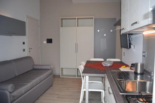 a kitchen and living room with a couch and a table at Orchidea Marina in Tirrenia