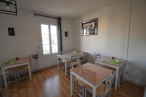 une chambre avec des tables, des chaises et une fenêtre dans l'établissement Hôtel du Commerce, à Millau